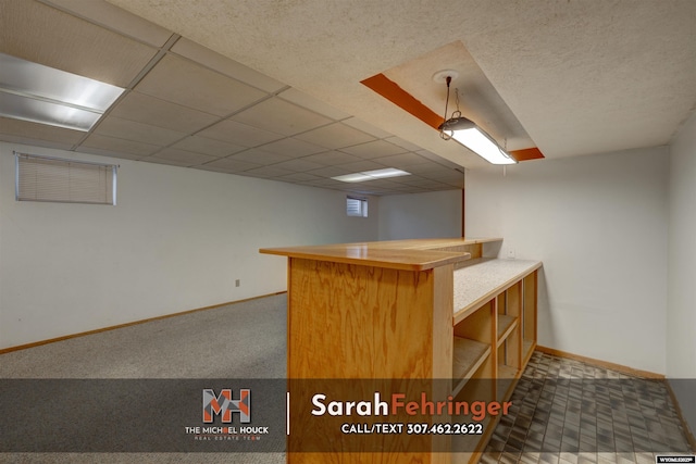 interior space featuring visible vents, a dry bar, a paneled ceiling, and baseboards