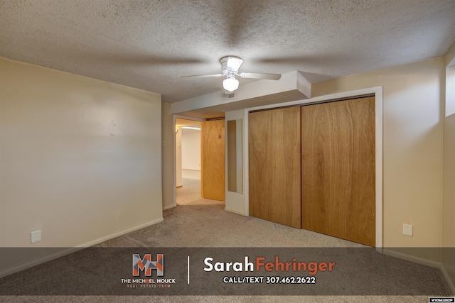 unfurnished bedroom featuring ceiling fan, carpet, baseboards, and a textured ceiling