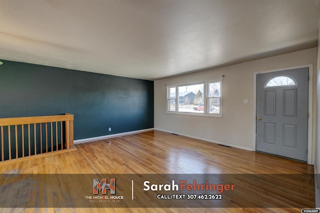 entryway featuring visible vents, baseboards, and wood finished floors