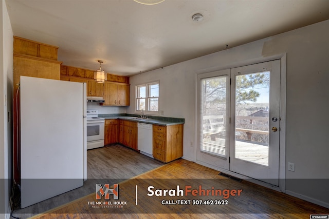 kitchen featuring visible vents, light wood-style flooring, under cabinet range hood, a sink, and white appliances