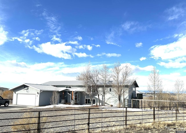 view of front of house with a fenced front yard, an attached garage, and driveway