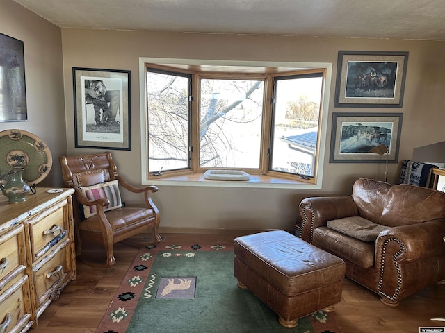 sitting room with baseboards and wood finished floors