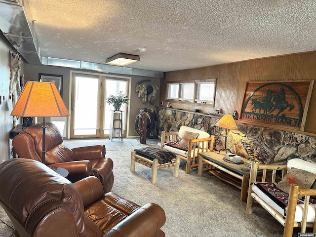 carpeted living room featuring wooden walls and a textured ceiling