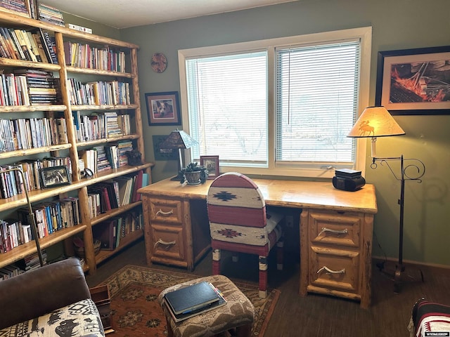 office area with wall of books and wood finished floors