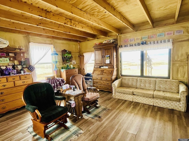 living area featuring a wealth of natural light, light wood-type flooring, beam ceiling, and wood ceiling