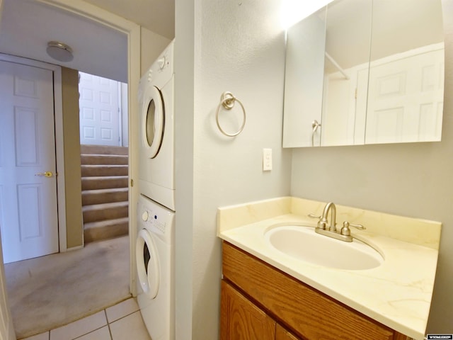 bathroom featuring vanity, stacked washer / drying machine, and tile patterned flooring