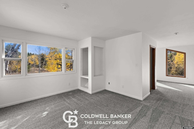 empty room featuring carpet and baseboards