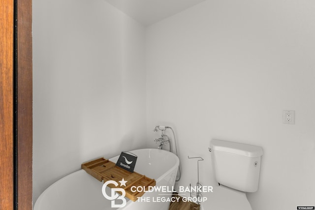 full bathroom with toilet and a freestanding bath