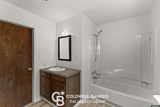 bathroom with vanity, wood finished floors, and washtub / shower combination