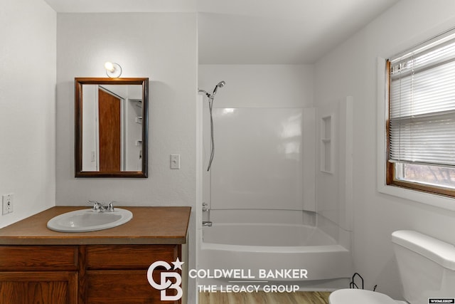 bathroom featuring toilet, vanity, and shower / tub combination