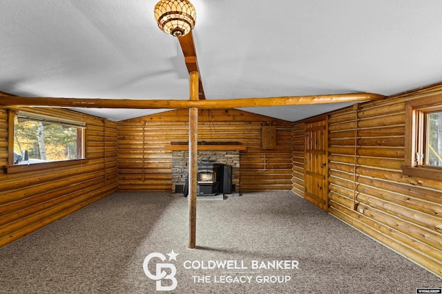 interior space with carpet, a wood stove, and a textured ceiling