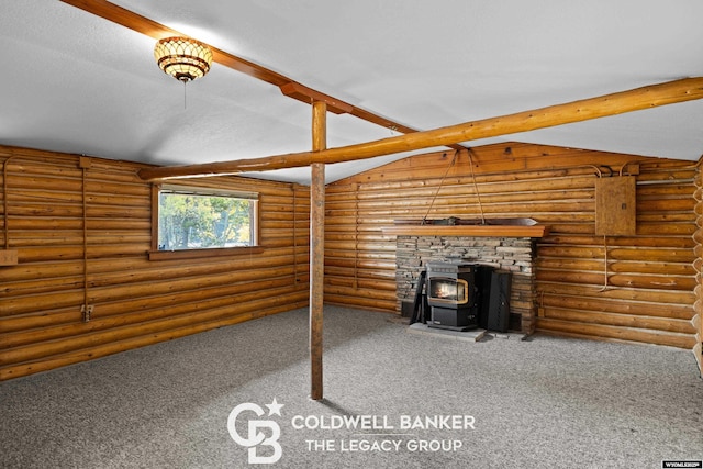 unfurnished living room featuring log walls, vaulted ceiling with beams, a wood stove, and carpet