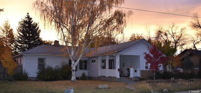 ranch-style home featuring a porch and a chimney