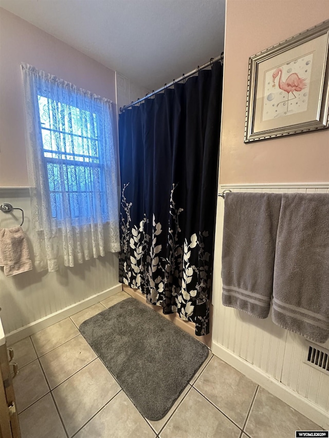 full bathroom with a shower with shower curtain and tile patterned flooring