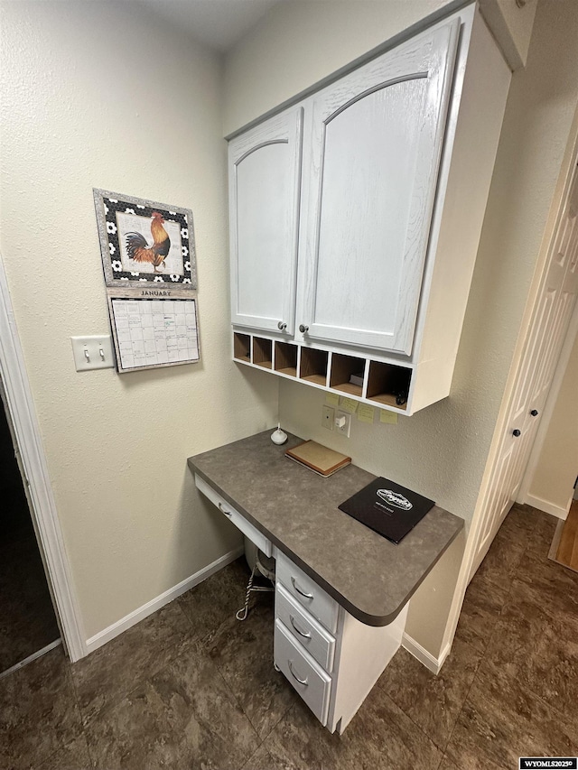 home office with baseboards and built in study area