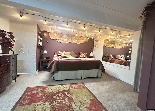 carpeted bedroom with track lighting and baseboards