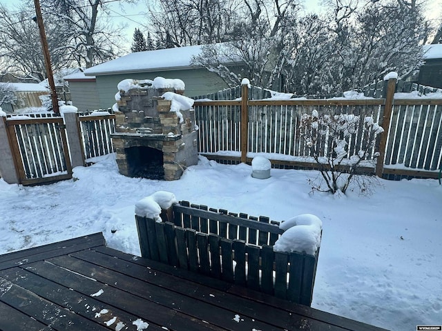 snow covered deck featuring fence