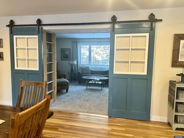 interior space with baseboards, light wood-style floors, and a barn door