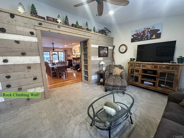 living area featuring a ceiling fan and carpet flooring