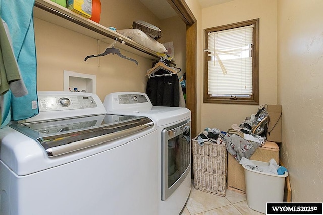 laundry area featuring laundry area, light tile patterned floors, and separate washer and dryer