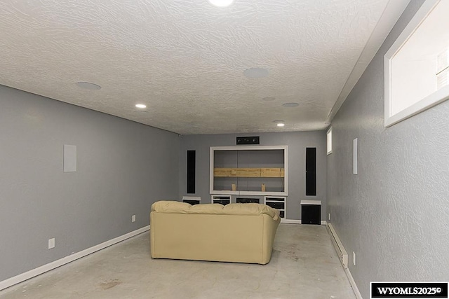 living area featuring a baseboard radiator, unfinished concrete flooring, a textured ceiling, and baseboards