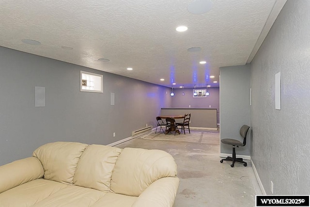 living area featuring unfinished concrete flooring, a textured wall, baseboards, and a textured ceiling