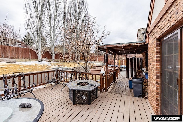 wooden terrace featuring an outdoor fire pit and fence