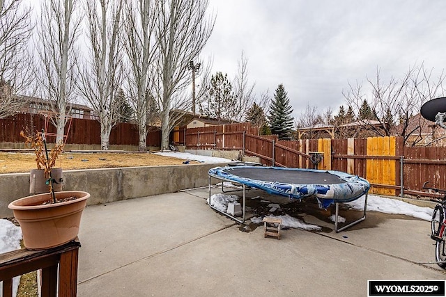 view of patio with a trampoline and a fenced backyard