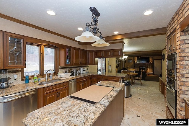 kitchen with a sink, a textured ceiling, appliances with stainless steel finishes, light tile patterned floors, and glass insert cabinets