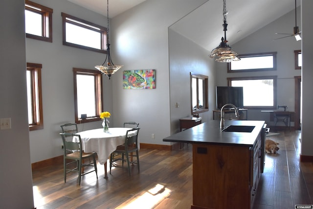 kitchen featuring a kitchen island with sink, dark wood-style flooring, ceiling fan, and a sink