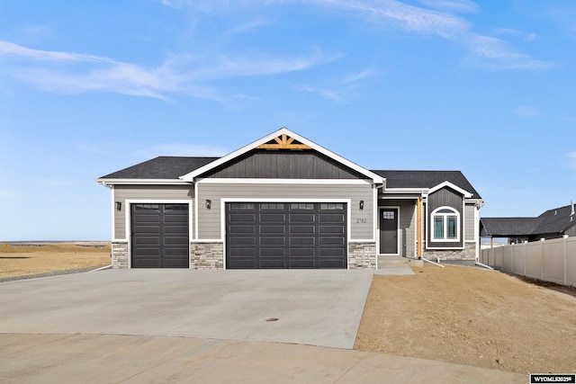 craftsman inspired home with stone siding, an attached garage, concrete driveway, and fence