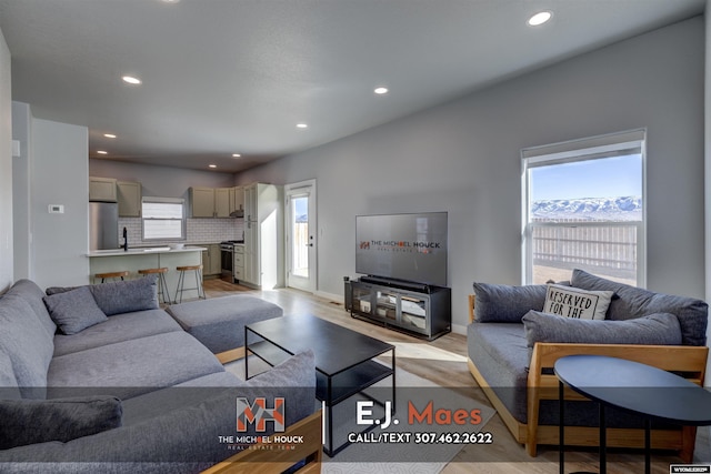 living room with recessed lighting, light wood-style floors, and a wealth of natural light