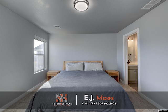 carpeted bedroom with baseboards, visible vents, and connected bathroom