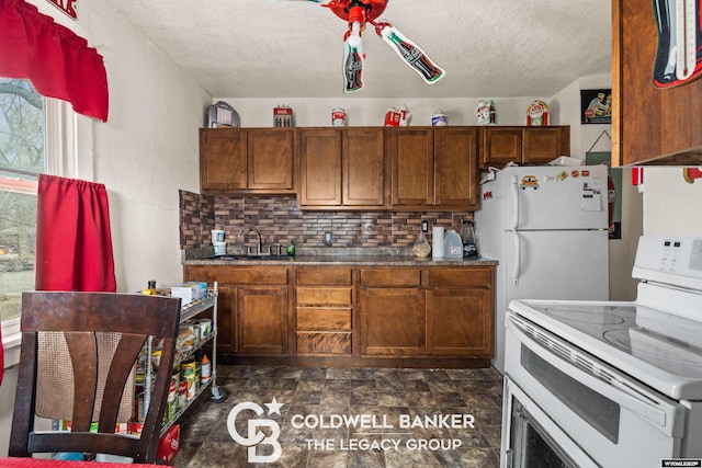 kitchen featuring white appliances, a sink, a textured ceiling, tasteful backsplash, and brown cabinets