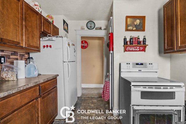 kitchen featuring white appliances and dark countertops