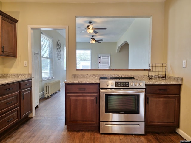 kitchen featuring baseboards, ceiling fan, radiator heating unit, electric stove, and dark wood-style floors