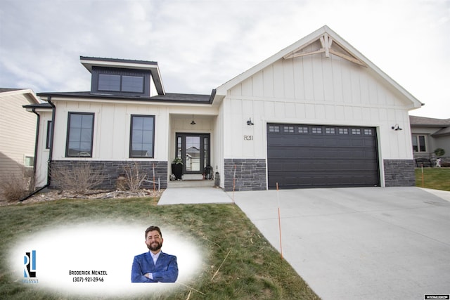 modern inspired farmhouse with stone siding, driveway, and an attached garage