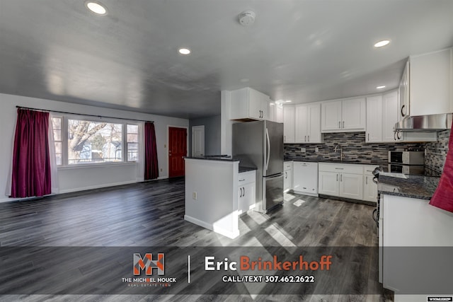 kitchen featuring dark wood finished floors, dishwasher, decorative backsplash, freestanding refrigerator, and a sink