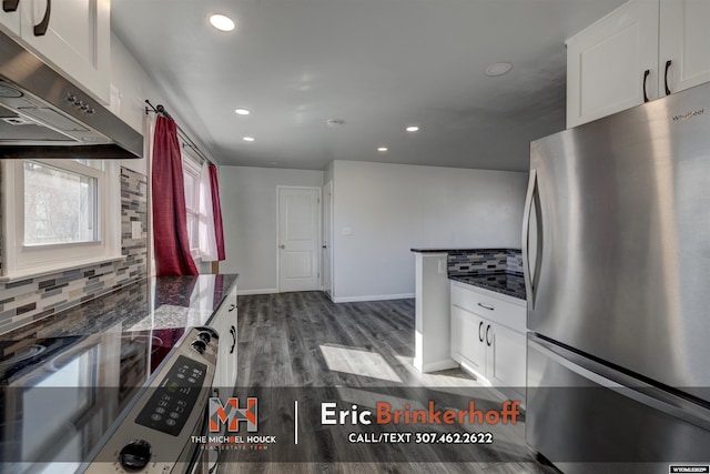 kitchen with electric range, freestanding refrigerator, decorative backsplash, under cabinet range hood, and white cabinetry