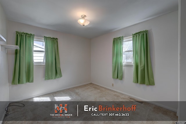 carpeted empty room with plenty of natural light, baseboards, and visible vents