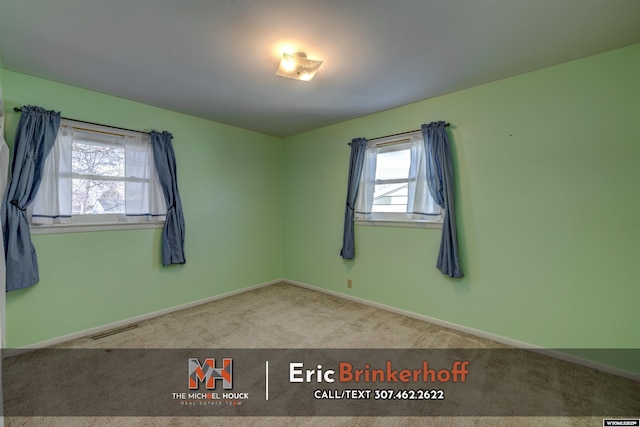 carpeted empty room with visible vents and baseboards