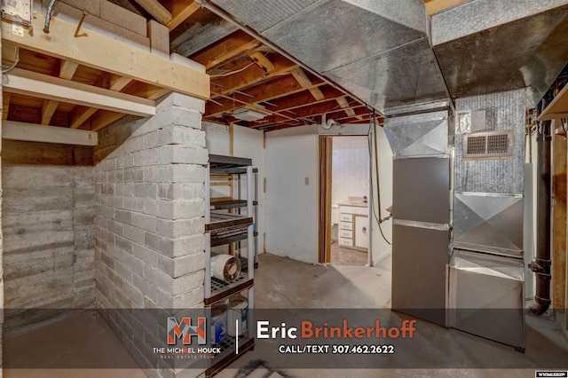 unfinished basement featuring visible vents and heating unit