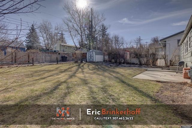 view of yard with an outdoor structure, a patio area, a fenced backyard, and a shed