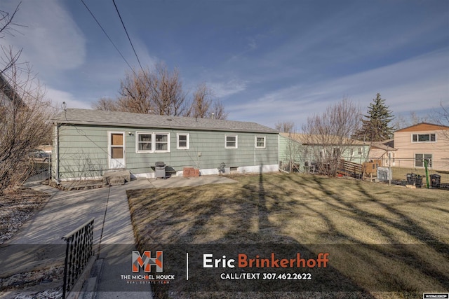 rear view of house with a yard and fence