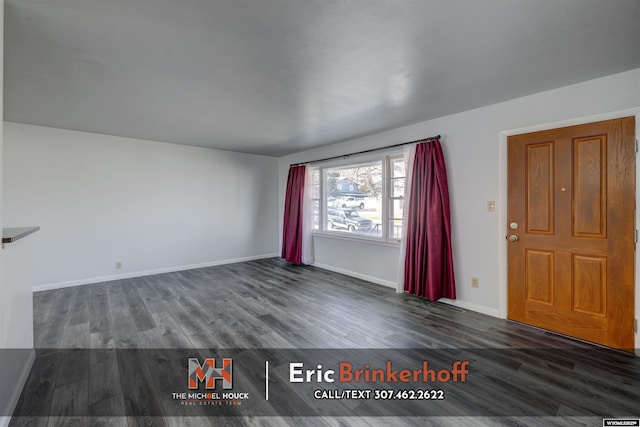 unfurnished living room with dark wood-style floors and baseboards