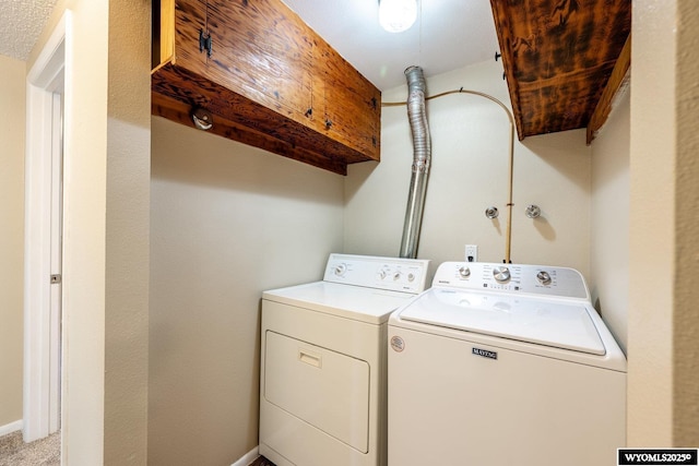 washroom with cabinet space, independent washer and dryer, and baseboards