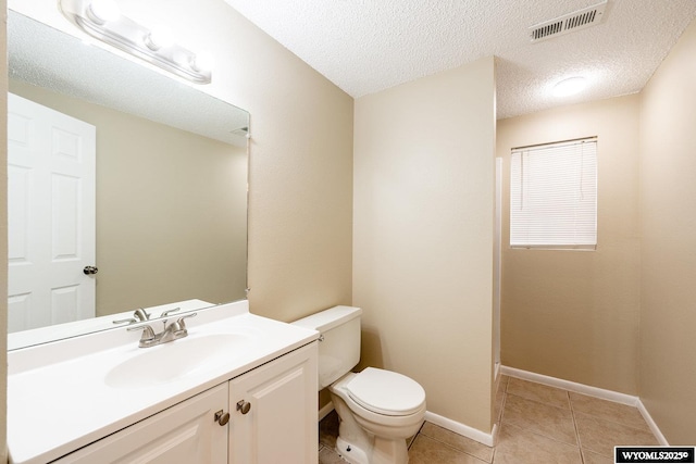 bathroom featuring vanity, visible vents, baseboards, tile patterned flooring, and toilet