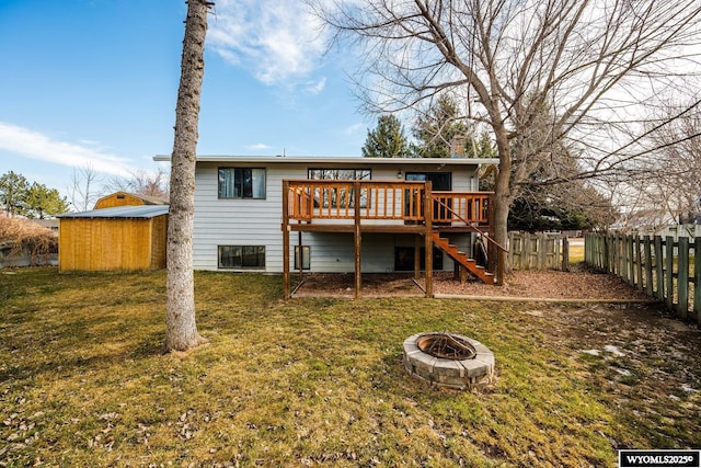 rear view of property with fence, an outdoor fire pit, a yard, stairs, and a deck