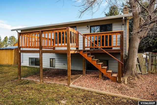 back of property featuring fence, stairway, a yard, a wooden deck, and a chimney