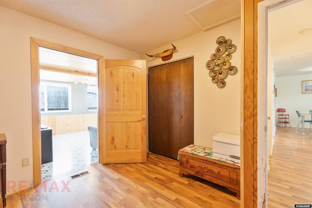 1242 Frontier Dr, Douglas, WY 82633 - hallway with visible vents, a textured ceiling, attic access, and wood finished floors